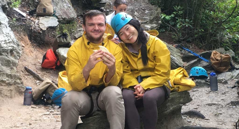 two gap year students rest on a rock on an outward bound expedition in the blue ridge mountains